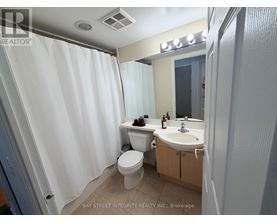 A white bathroom with a toilet, sink, and shower curtain.