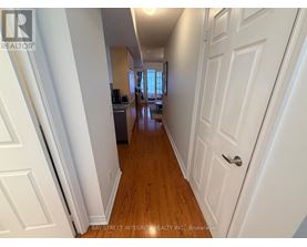 A hallway with white doors and wooden floors.
