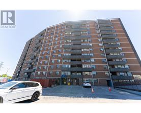 A tall apartment building with a white car parked in front.
