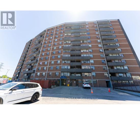 A tall apartment building with a white car parked in front.