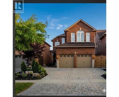 A house with a brick facade and a large driveway in front.