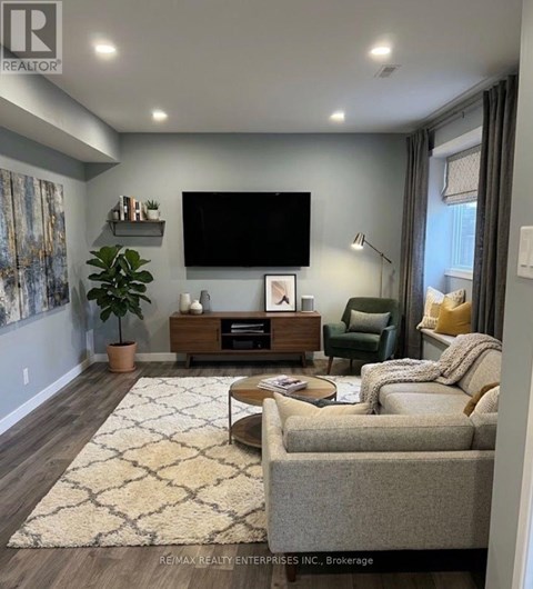 A living room with a flat screen TV mounted on the wall.