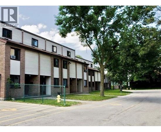 A building with a fence and a fire hydrant in front of it.