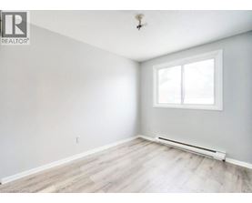 A room with a window and a radiator on the floor.