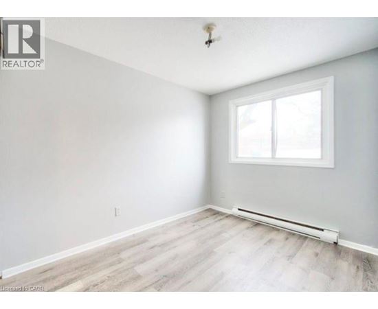 A room with a window and a radiator on the floor.