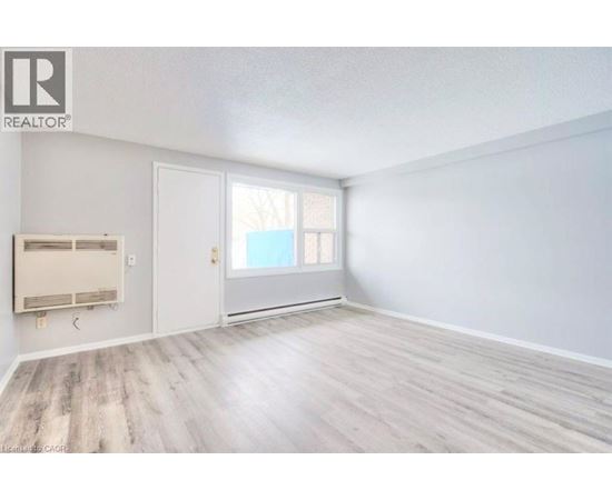 A room with a window and a door is available for rent.