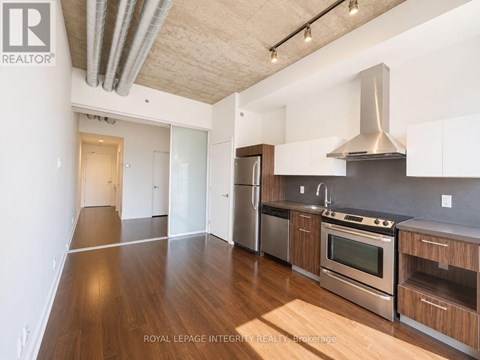 A kitchen with wooden floors and stainless steel appliances.