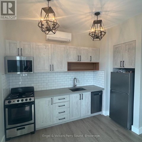 A kitchen with white cabinets and a black stove top oven.