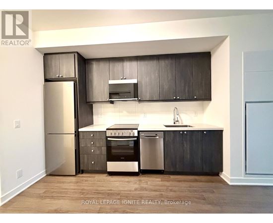 A modern kitchen with dark wood cabinets and stainless steel appliances.