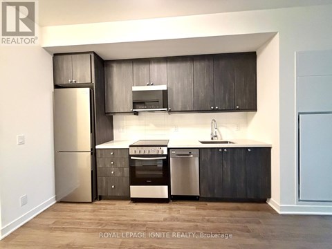 A modern kitchen with dark wood cabinets and stainless steel appliances.