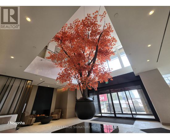 A large vase with a tree in it is in the middle of a room.