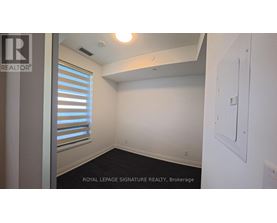 A white wall with a light switch and a window with blinds.