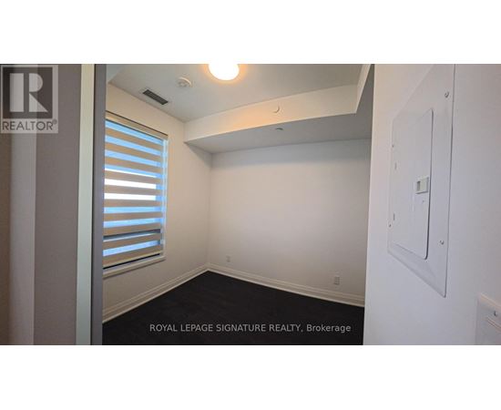 A white wall with a light switch and a window with blinds.
