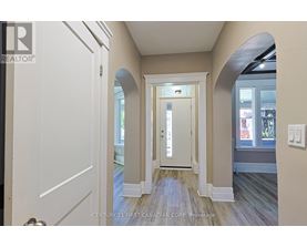 A hallway with a white door and a window.