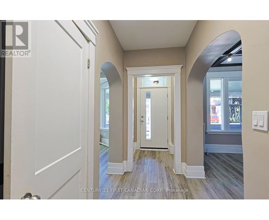 A hallway with a white door and a window.