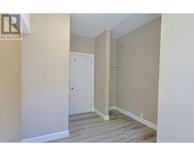 A room with a white door and a wooden floor.