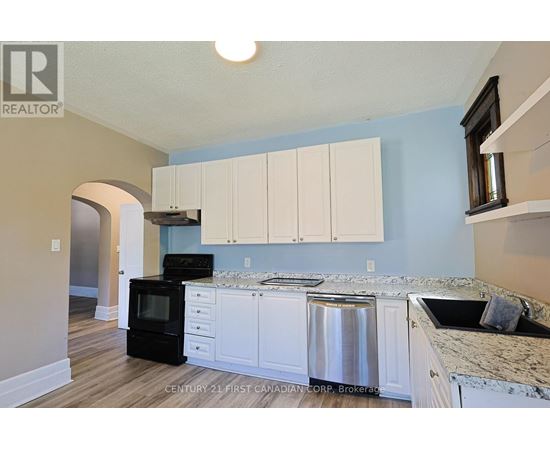 A kitchen with white cabinets and a black stove top oven.