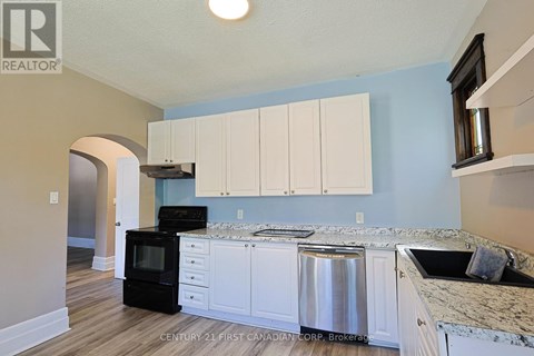 A kitchen with white cabinets and a black stove top oven.