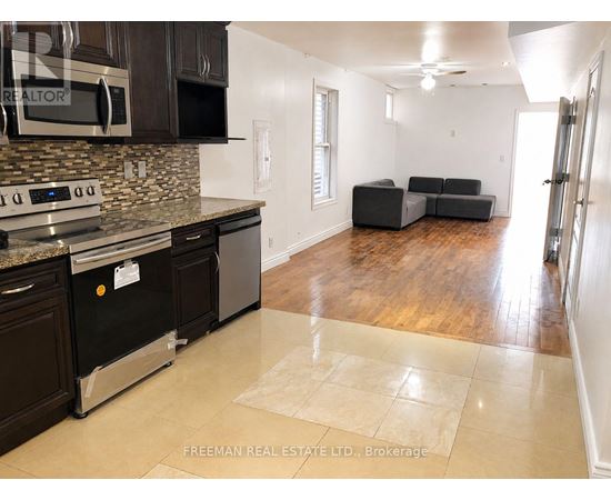 A kitchen with a stone backsplash and a black oven.