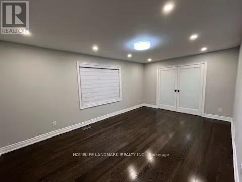 A room with wooden flooring and white walls.