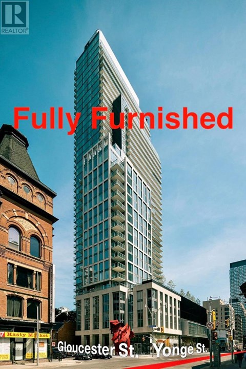 A tall, modern building stands between two older buildings on a street corner.