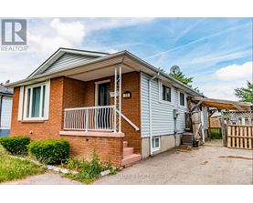 A house with a red brick exterior and a white door is for sale.