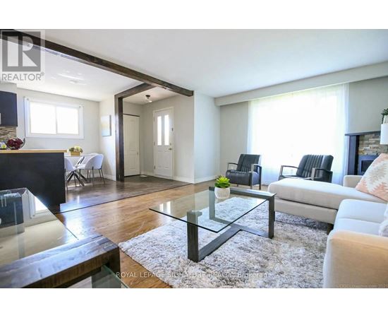 A modern living room with a glass coffee table and a white sofa.