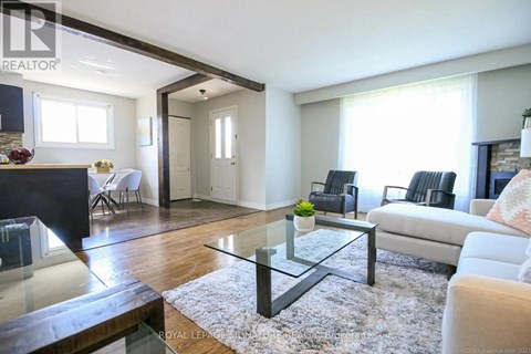 A modern living room with a glass coffee table and a white sofa.