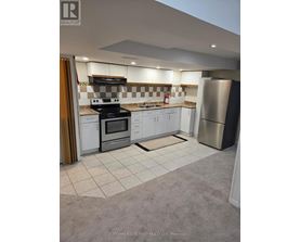 A kitchen with a checkered tile backsplash and white cabinets.