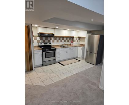 A kitchen with a checkered tile backsplash and white cabinets.