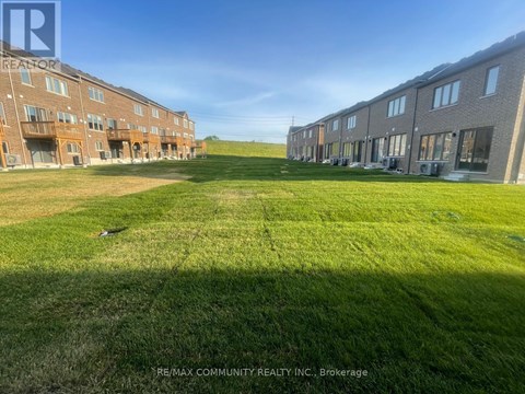 A grassy field in front of apartment buildings.