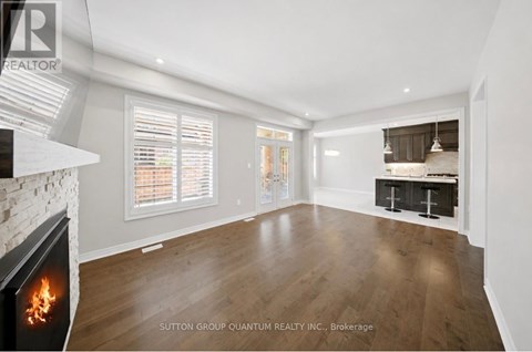 A modern living room with a fireplace and a view of the kitchen.