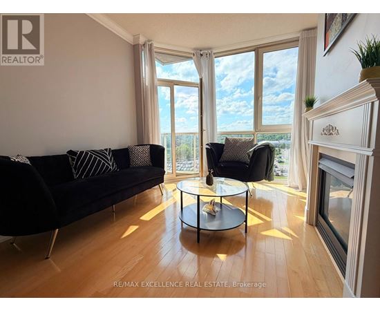 A living room with a black couch and a glass table.
