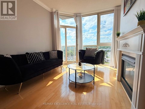 A living room with a black couch and a glass table.