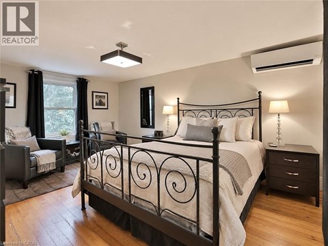 A bedroom with a large bed and a window with curtains.