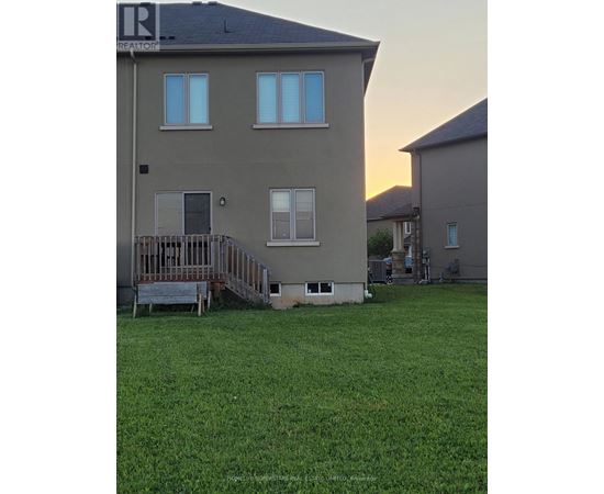 A house with a deck and a green lawn in front.