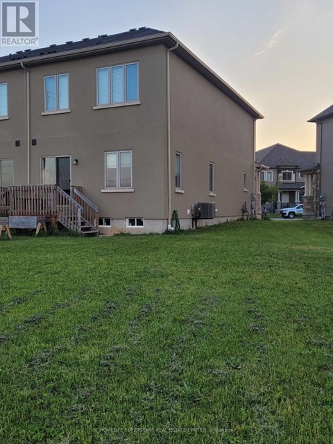 A large grassy yard in front of a two-story building.