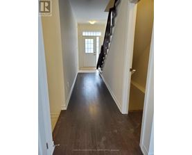 A hallway with wooden floors and white walls.