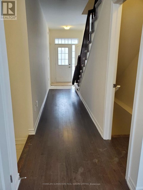 A hallway with wooden floors and white walls.