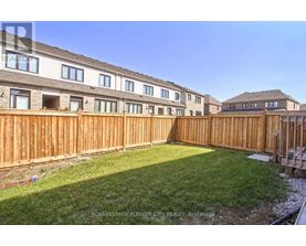 A sunny day at a residential area with apartment buildings and a wooden fence.