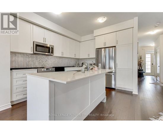 A kitchen with white cabinets and a counter top.