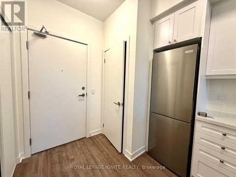 A kitchen with white cabinets and a stainless steel refrigerator.