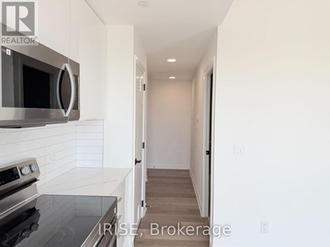 A modern kitchen with a stove top oven and microwave above it.