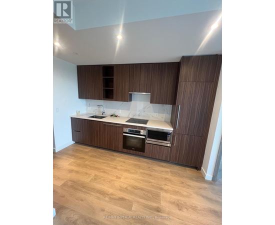 A modern kitchen with wooden cabinets and stainless steel appliances.