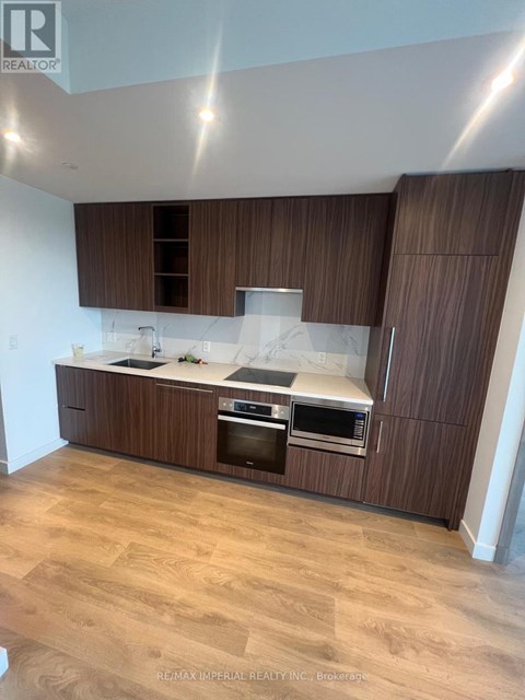 A modern kitchen with wooden cabinets and stainless steel appliances.