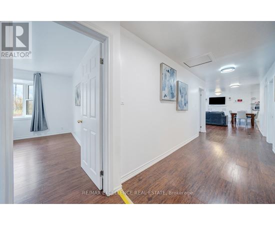 A room with a white door and a painting on the wall.
