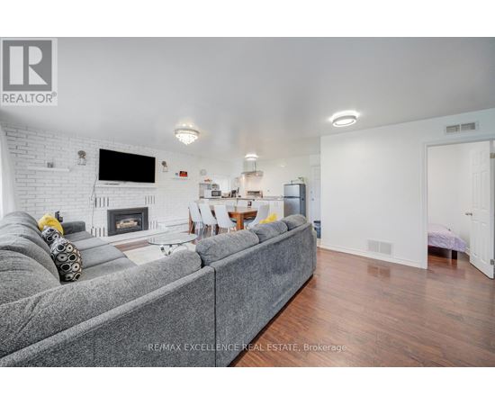 A living room with a grey couch and a fireplace.