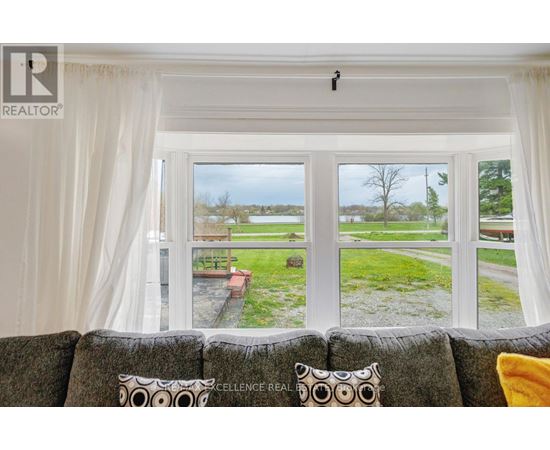 A living room with a couch and a window overlooking a lawn.