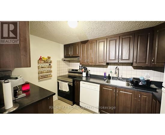 A kitchen with brown cabinets and a black countertop.