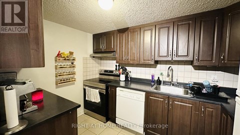 A kitchen with brown cabinets and a black countertop.
